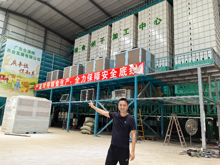 工作人员介绍烘干机烘干稻谷的流程。肇庆市融媒体中心记者 杨丽娟 摄